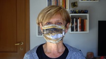 a woman taking off a face mask and smiling 