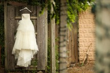 wedding dress hanging on a door outside