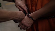 Prison guard removes handcuffs from a prisoners hands in cinematic slow motion.