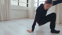 Young inspired female performer improvising and dancing contemporary style while practicing at the studio
