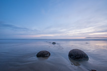 Large round boulders on a sandy beach.