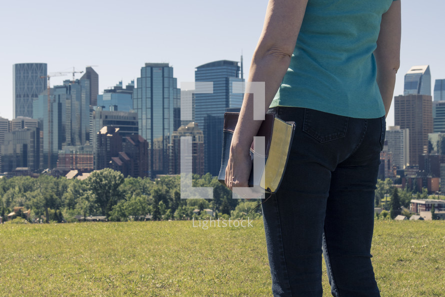 Woman with Bible and City Skyline 