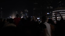 Large crowd of mixed race of people at the Dubai mall fountain in United Arab Emirates.