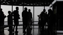 Silhouettes of a large crowd of people, families, tourists inside the top of the Burj Khalifa in Dubai.