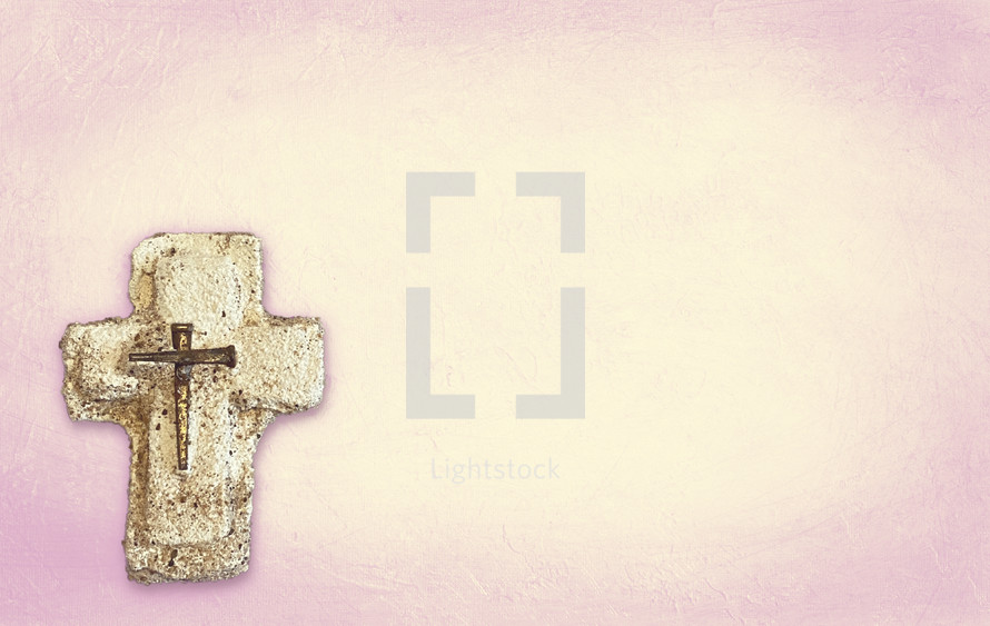 plaster cross with nails on peach pink duotone textured paint.