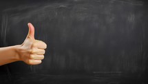 Hand Showing Thumbs on Chalkboard Background