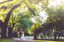 portrait of a bride and groom standing under a tree 
