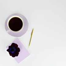 coffee cup, pen, and journal on a white background 