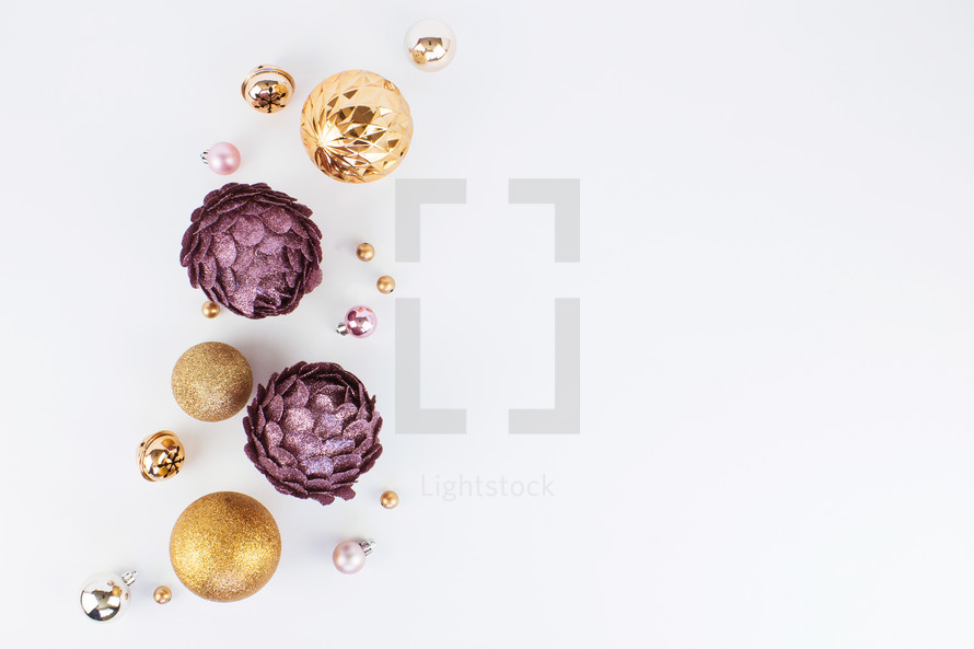 silver, pink, purple, and gold Christmas ornaments on white 