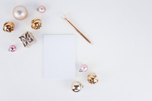 notepad, pen, and Christmas ornaments on a white background 