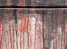 paint streaks on concrete wall texture in red, orange and gray