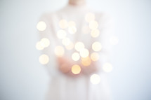 a woman holding fairy lights 