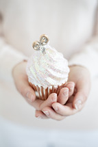 a woman holding a cupcake 