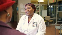 African American woman doctor interacting with patient 