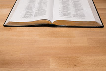 open pages of a Bible on a wood 