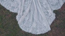 The train of a wedding dress laid in the grass