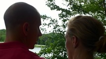 couple sitting by a lake 