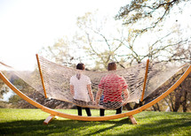 man and woman sitting on a hammock