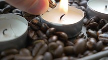 lighting candle surrounded by coffee beans