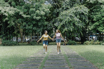 teen girls walking holding hands 
