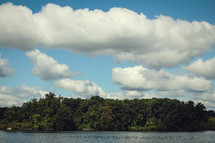 clouds in a blue sky over a lake 