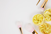 makeup brushes and yellow flowers 