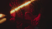 Close-Up of Man Playing Rock Music on the Guitar in Dark Room with Light Beam