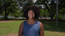 Portrait of black man very happy, smiling at outdoors park background. An african american student sincerely smiles while standing at the park. 
