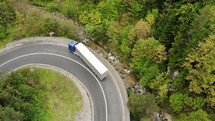 Aerial view of a vehicles driving on a winding road in Bicaz Gorge in Romania.