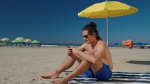 relaxed caucasian man hold use smart phone watching social media sitted at the beach 