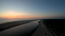 Aerial drone shot overlooking a big puddle of water on a beach at sunset on Langeoog island at the Nordsee in North Germany.