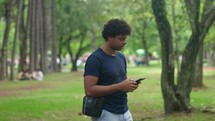 Young latino man holding mobile phone, using online app on smartphone, texting, chatting typing message, touching screen
