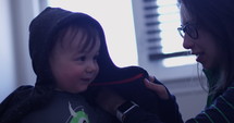 young mom putting sweater on toddler - slow motion