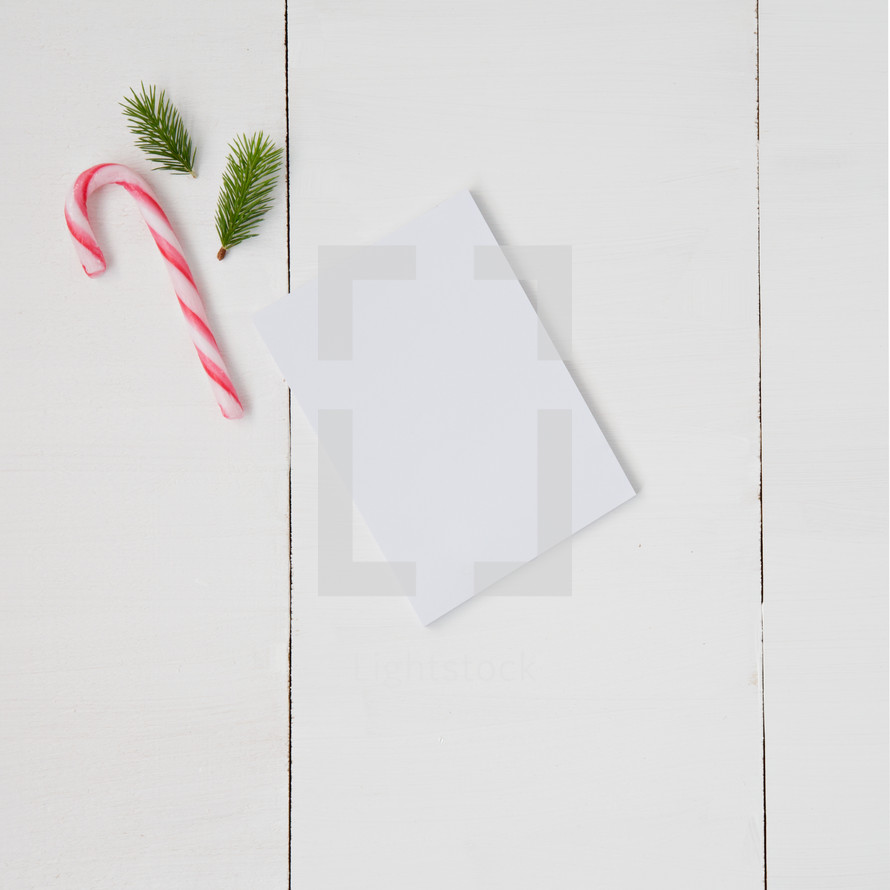 candy canes, pine boughs, and blank white paper 