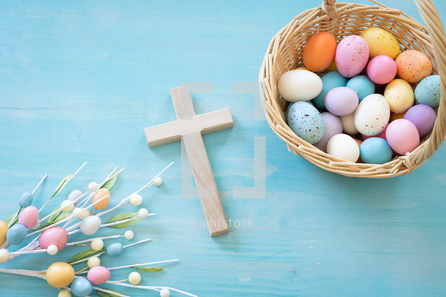 Basket of Easter eggs and cross on a blue background
