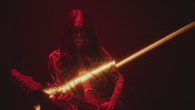 Musician Playing Electric Guitar in Dark Studio with Light Beam