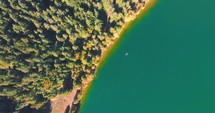 Top Down View Of Turquoise Water With Kayak At Lake Saint Ann In Romania - aerial drone shot