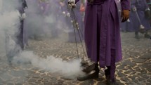 Men In Purple Robe Putting Incense Smoke At The Procession In Antigua, Guatemala - medium shot	