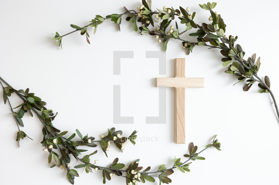 Cross and branch with white berries on a white background