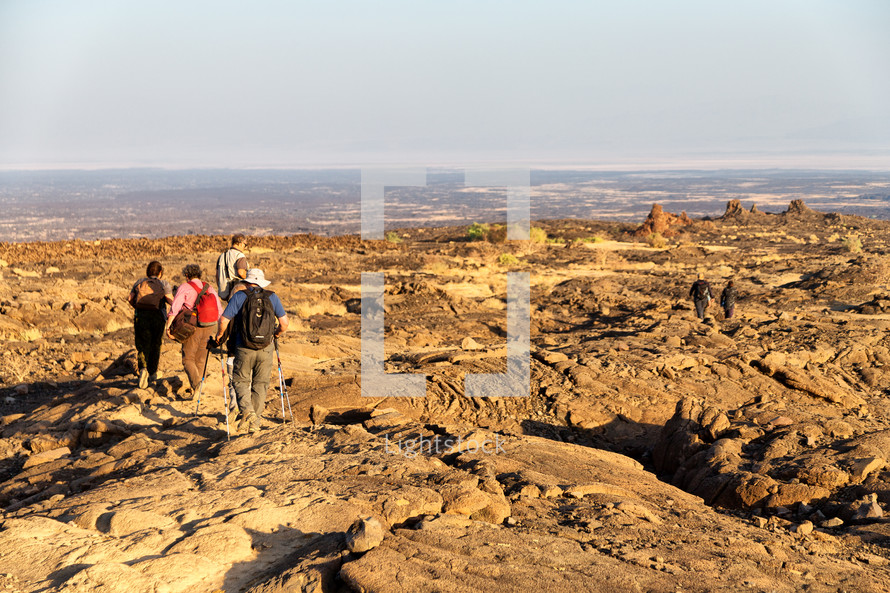 backpackers walking on rugged landscape in Africa 