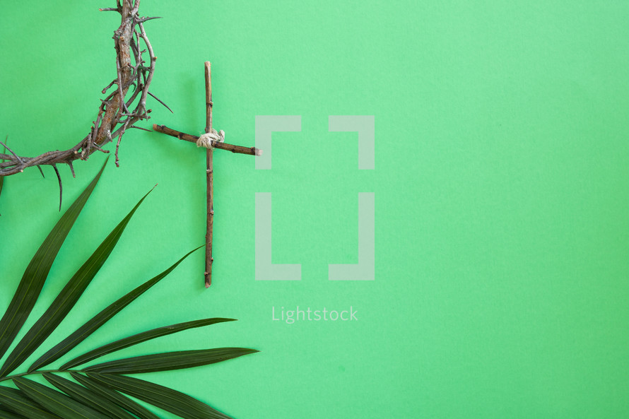 palm frond, cross of sticks, and crown of thorns on green 