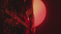 Rock Guitarist Performing in Dark Studio with Red Light