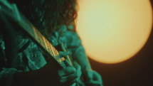 Long-Haired Guitarist Playing Rock Music in Dark Studio
