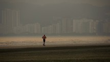 Man running on the beach alone in Santos Brazil
