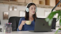 Serious woman student wears headphone and studies online 