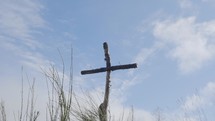slow motion panning shot of cross with sky in the background.
