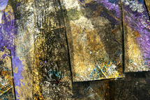 abstract painted surface resembling boards, in gold, tan, black, purple