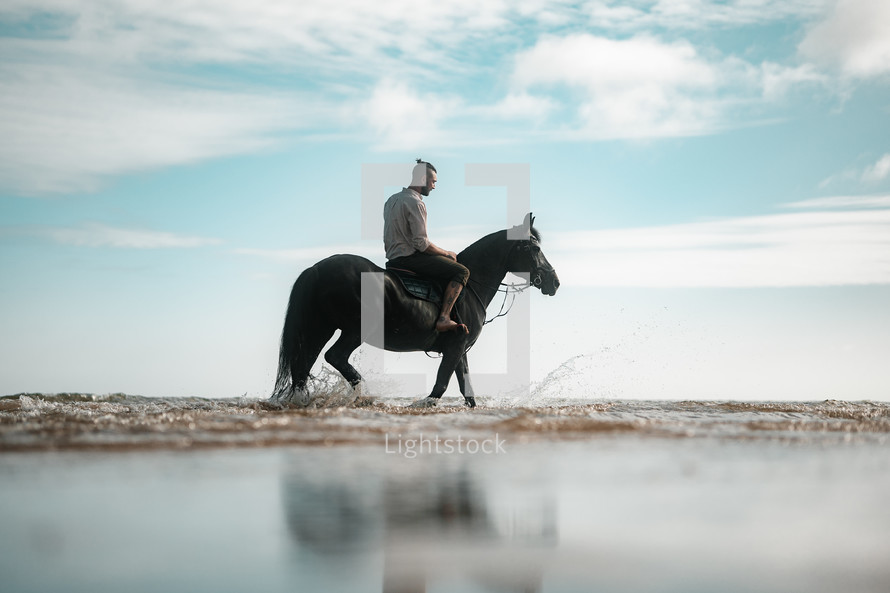 Horse riding on a beach, equestrian man riding on a horse