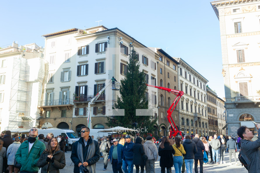 Florence, Italy - December 03, 2023: Christmas tree installation in the central square of Florence. Workers on lifting platforms mount the Christmas lights.