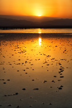 sunset over the shore of a salt lake 